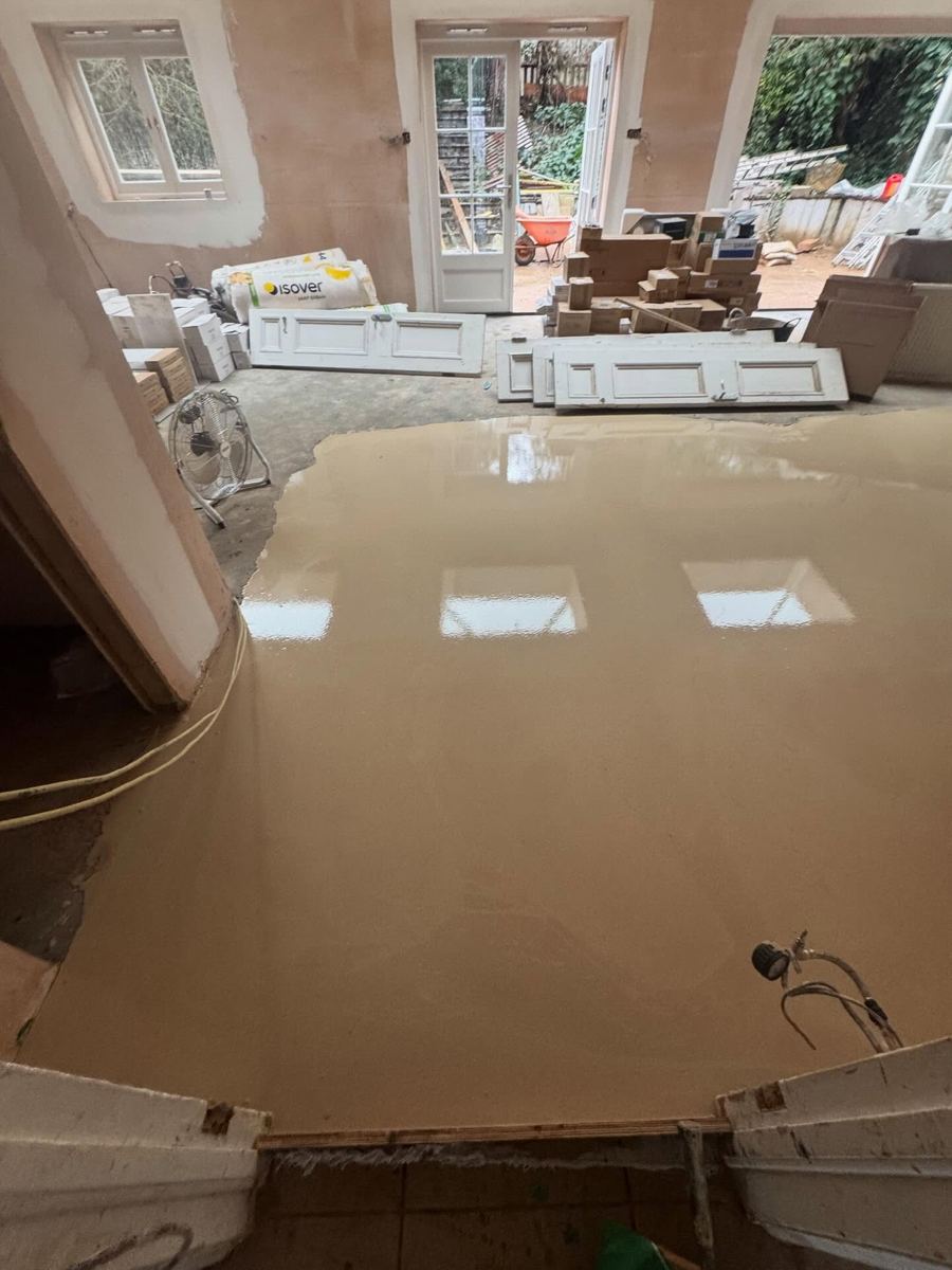 Freshly poured liquid screed with a mirror-flat finish in a house renovation