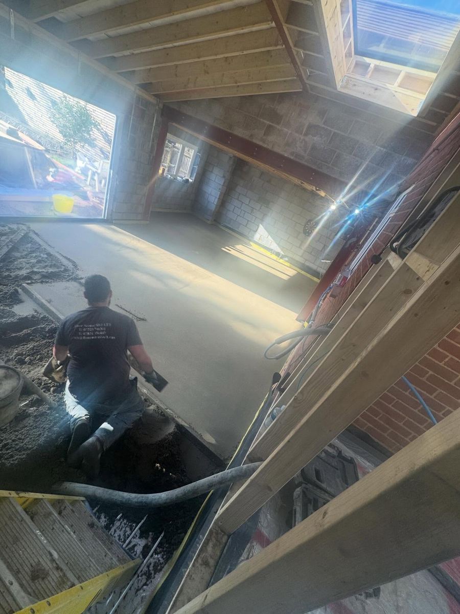 Luke Almandras hand-finishing a floor screed in a new extension